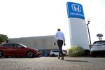 A worker walks through the lot of Paragon Honda and Acura car dealership in the Queens borough of New York, U.S., on Thursday, July 15, 2021.
