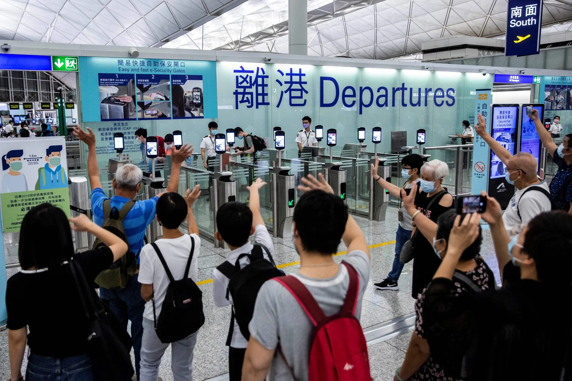 Family members bid farewell to relatives starting new lives overseas at Hong Kong International Airport on July 22.