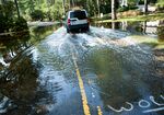 A driver passes through a street flooded by rain from Hurricane Irene on August 28, 2011 in Virginia Beach, Virginia.&nbsp;