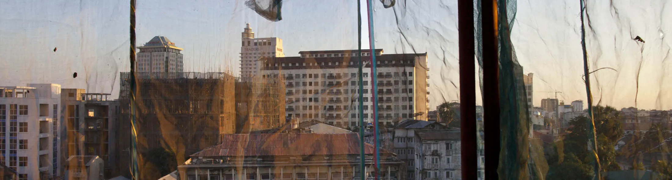 YANGON, MYANMAR - FEBRUARY 6: Buildings are seen in Yangon through a netting used to protect buildings from construction sites February 6, 2012 in Yangon, Myanmar. In the unreliable and volatile market of Burma many big investors have put all of their money in the real estate market as a building boom continues in Yangon. As the country opens up to the outside world and Suu Kyi begins her campaign ahead of April 1 by-elections, her decision to stand for a seat in parliament is the latest sign of dramatic political changes taking place in the country.
