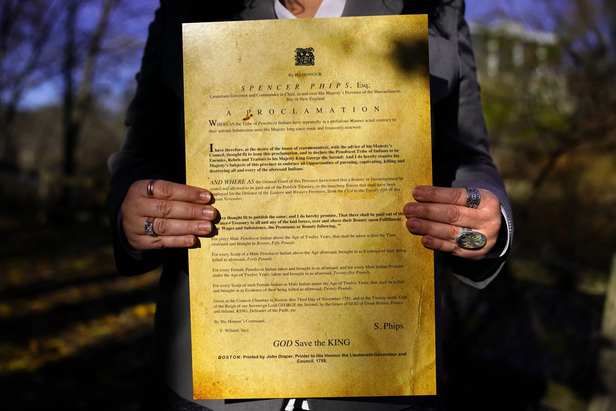 Dawn Neptune Adams holds a copy of the Phips Proclamation of 1755, Tuesday, Nov. 23, 2021, in Bangor, Maine. Adams recently co-directed a film that focuses on the proclamation, one of the dozens of government-issued bounty proclamations that directed colonial settlers to hunt, scalp and kill Indigenous people for money. (AP Photo/Robert F. Bukaty)
