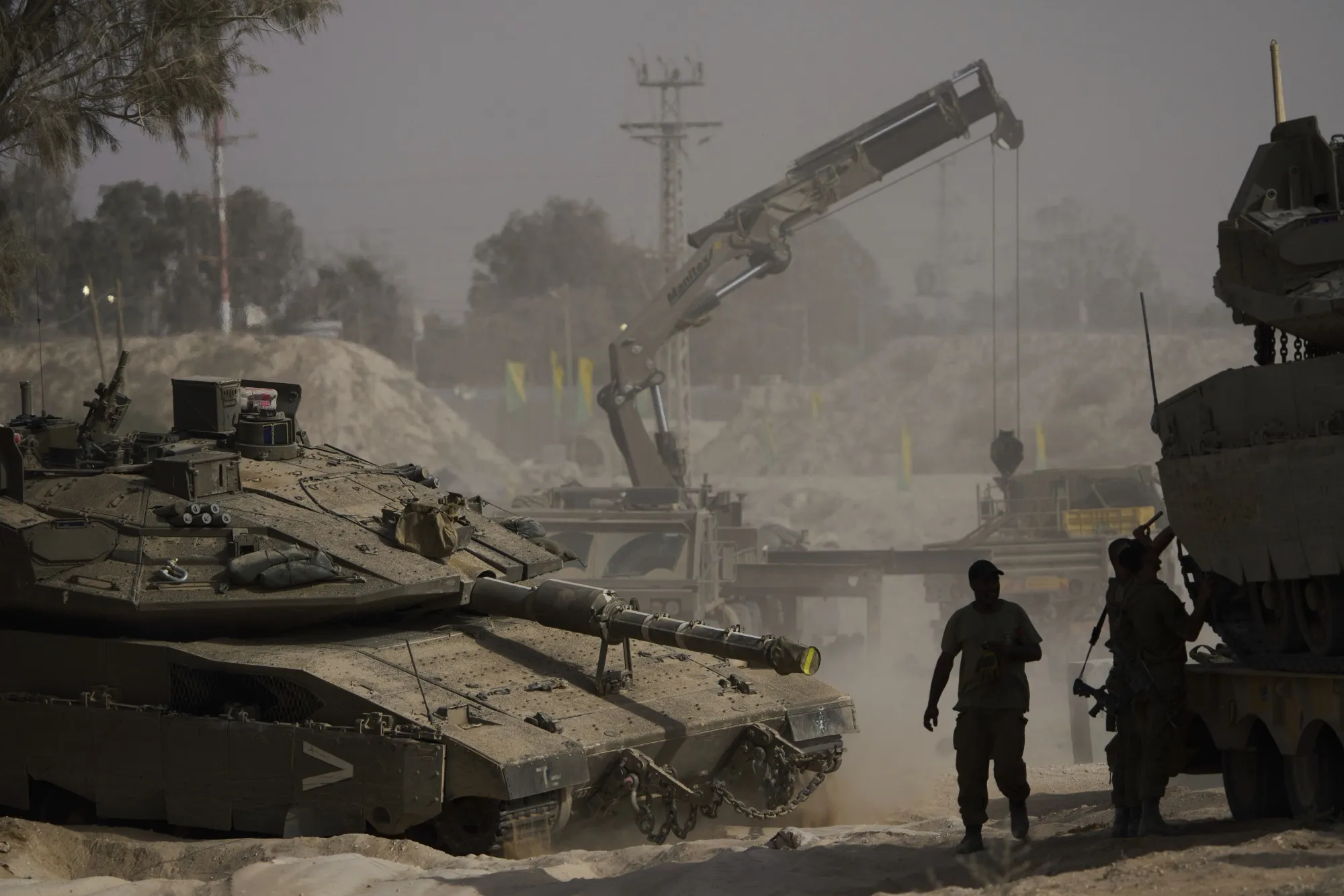 Israeli soldiers work on tanks at a staging area near the border with Gaza on July 1.