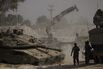 Israeli soldiers work on tanks at a staging area near the border with Gaza on July 1.