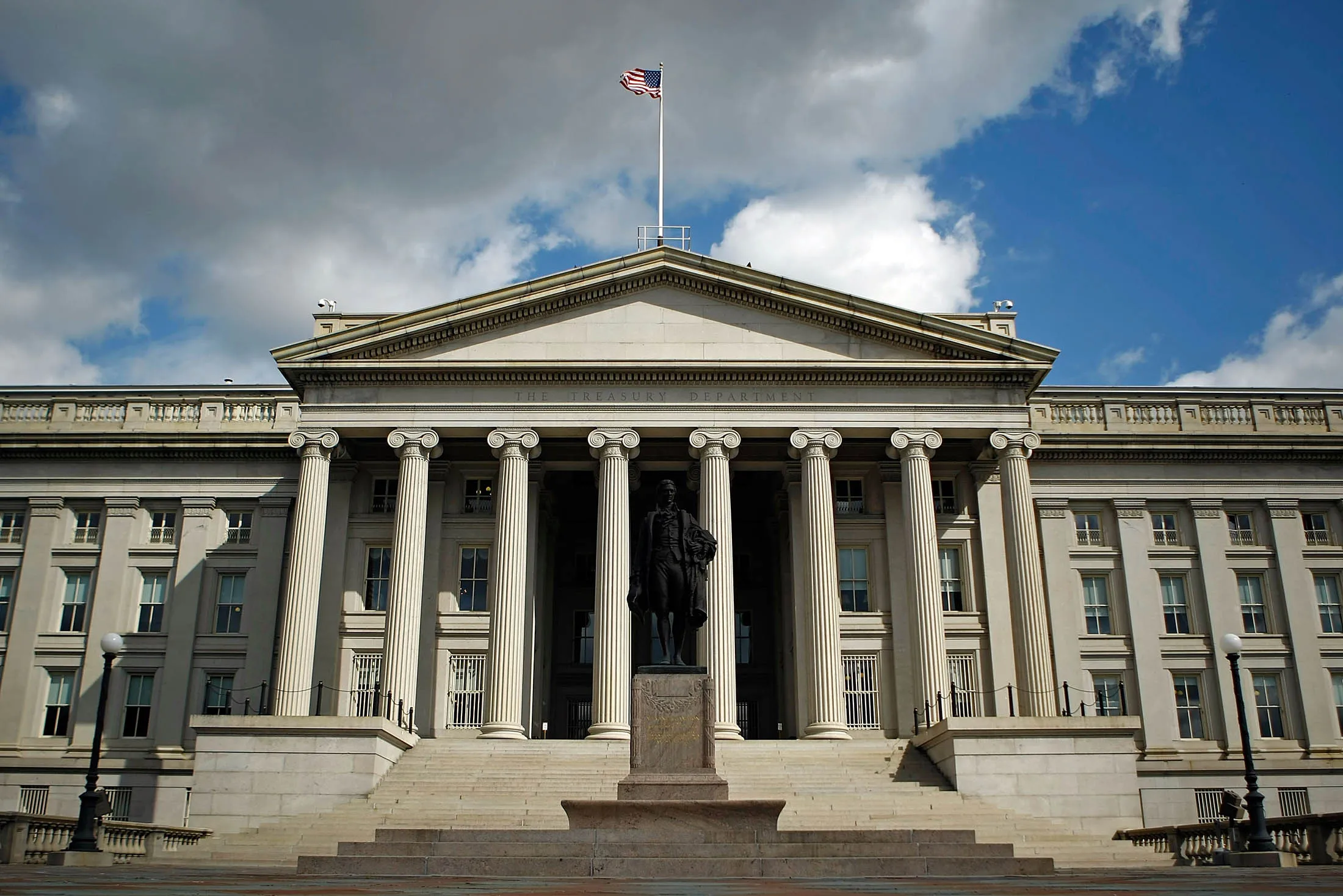 Statue of Alexander Hamilton stands in front of the U.S. Treasury.
