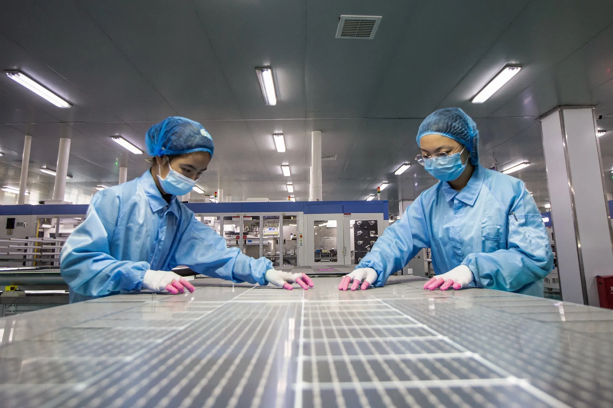 Employees work on solar photovoltaic modules at a factory in Haian, China.&nbsp;