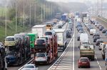 Car transporter lorries travelling among congested traffic on M1 motorway in Hertfordshire, UK.