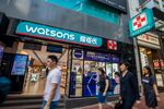 Pedestrians walk past a Watsons store in Hong Kong.