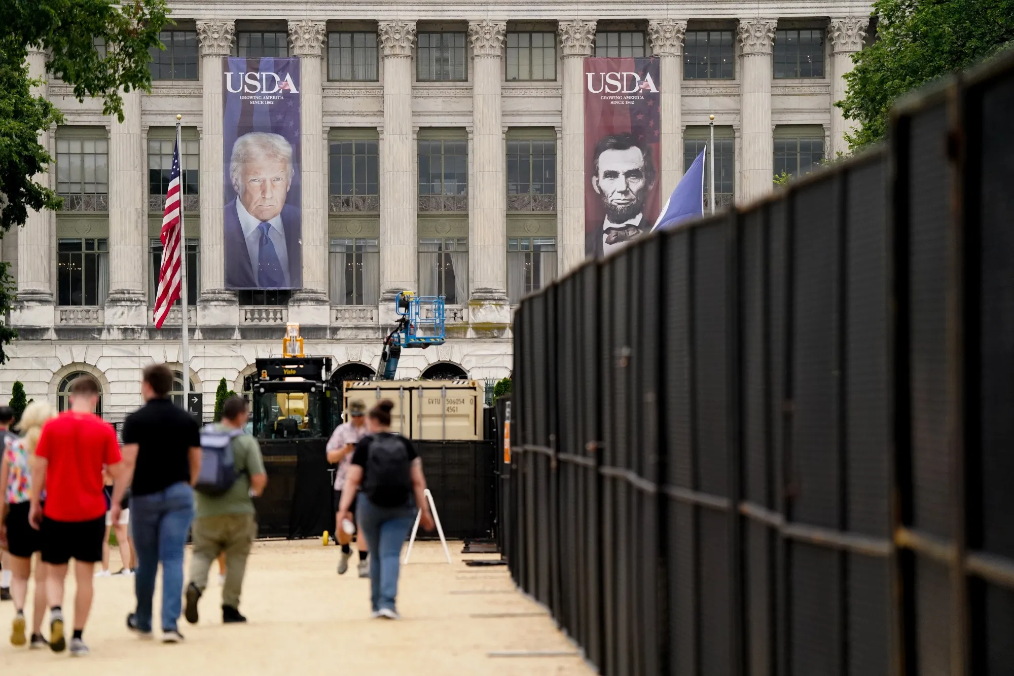 Security fencing near images of US President Donald Trump and former US President Abraham Lincoln on the USDA&nbsp;building ahead of the US Army's 250th Anniversary Parade in Washington, DC on June 14, 2025.&nbsp;