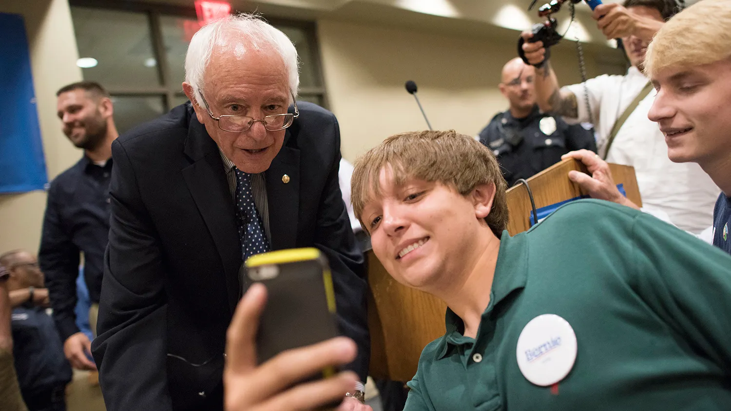 Senator Bernie Sanders, an Independent from Vermont and 2016 U.S. presidential candidate, left, takes a 'selfie' photograph with an attendee during a town hall meeting in Davenport, Iowa, U.S., on Thursday, May 28, 2015.

