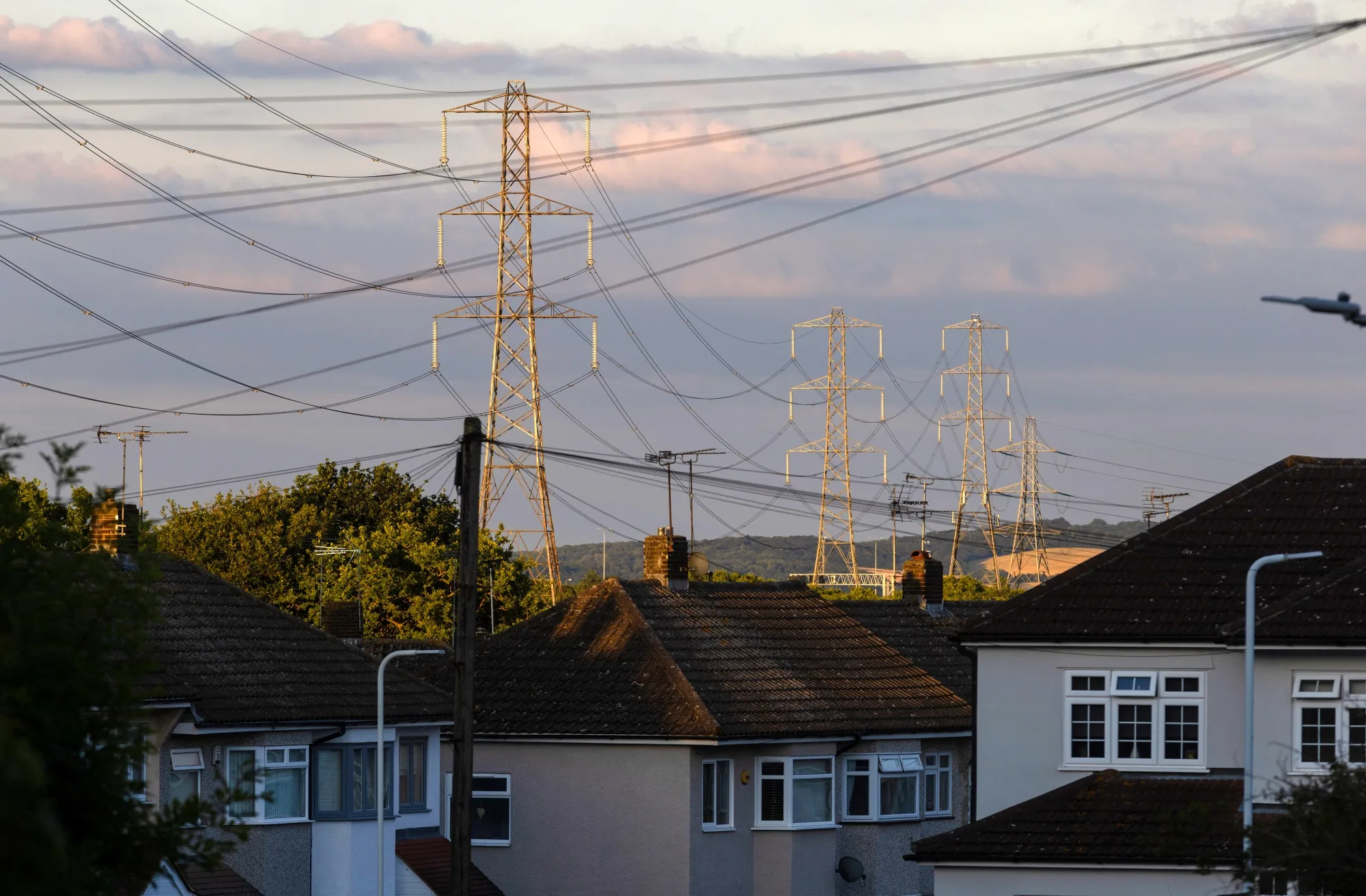 Electricity transmission towers near residential houses in Upminster, UK.