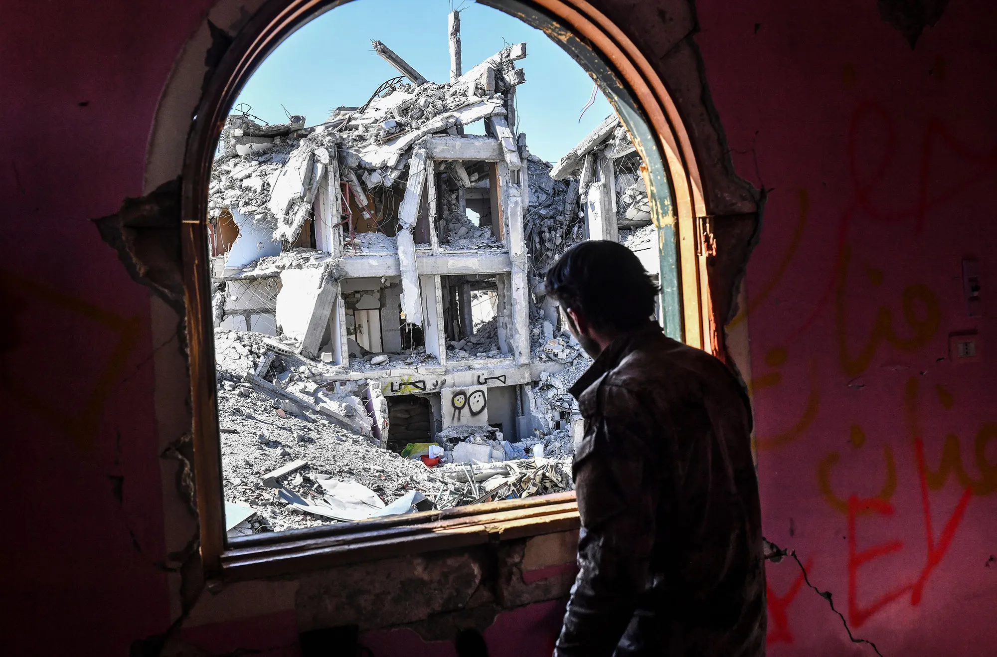 A member of the Syrian Democratic Forces&nbsp;looks out from a building at the frontline in Raqa on Oct. 16, 2017.
