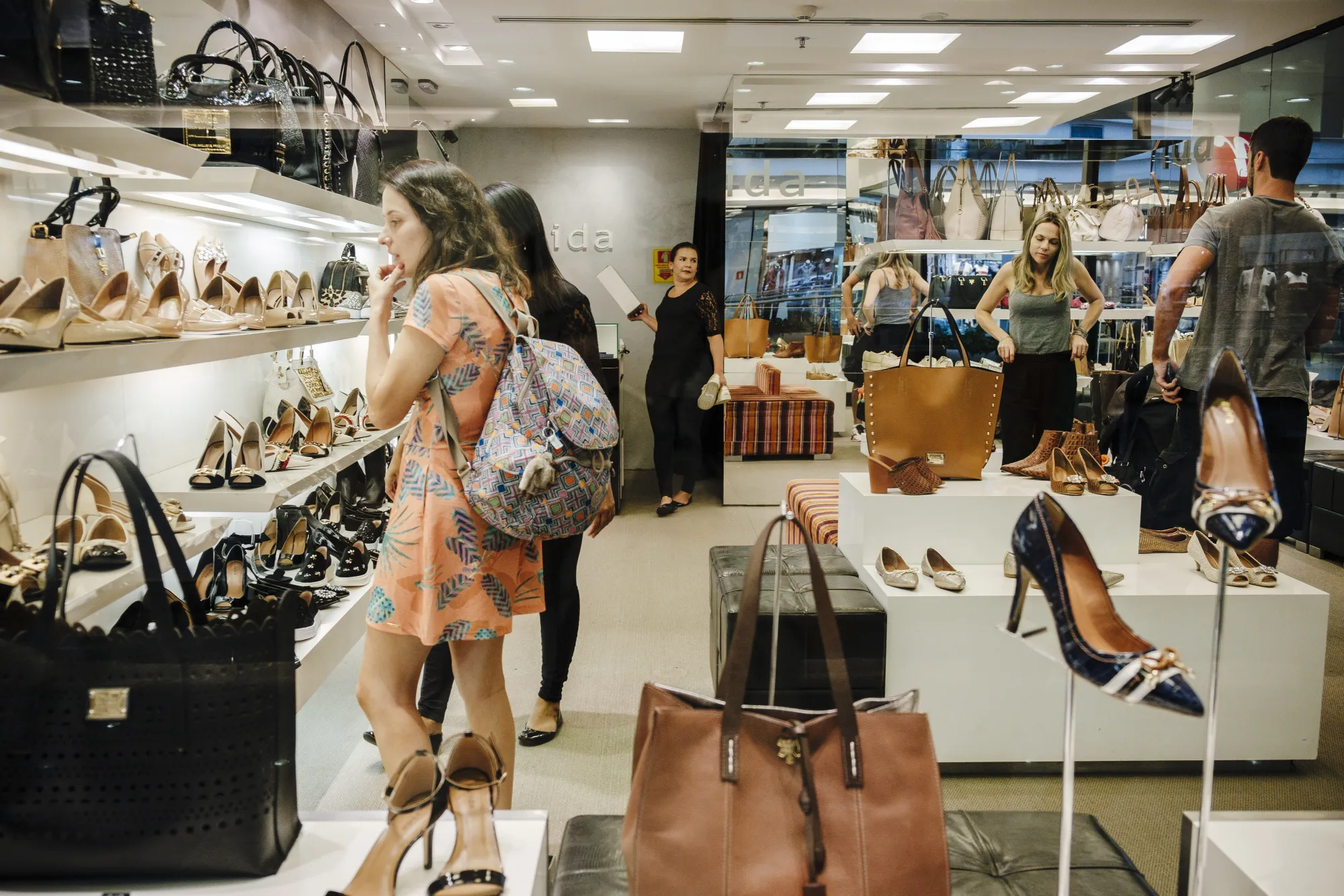 Shoppers view shoes on display for sale inside an Avida store at the Brasilia Shopping Center in Brasilia, Brazil.