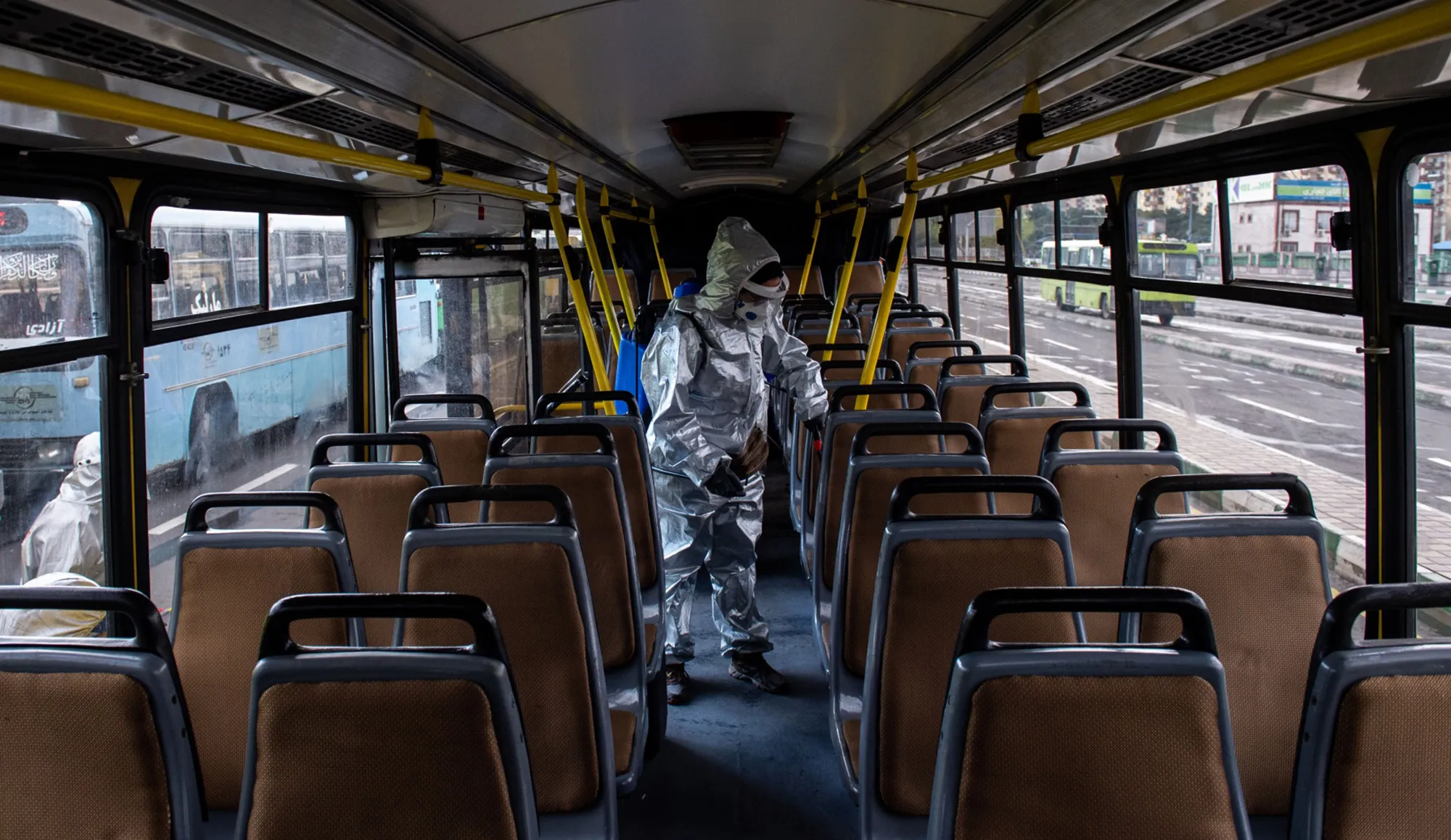 A worker disinfects a public bus in Tehran.