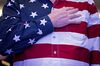 An attendee wearing an America flag shirt stands for the Pledge of Allegiance at the Conservative Political Action Conference (CPAC) in National Harbor, Maryland, U.S.