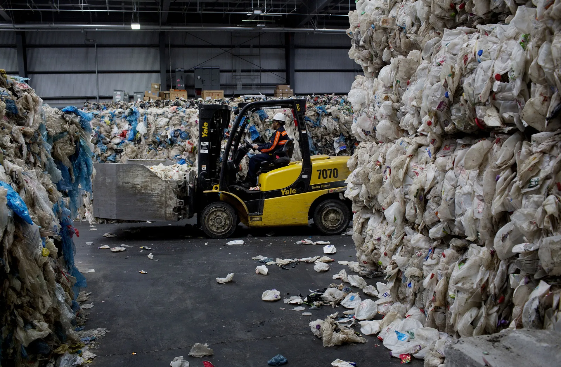 A worker moves bales of plastic bottles&nbsp;at the Sims Municipal Recycling facility in New York City.&nbsp;