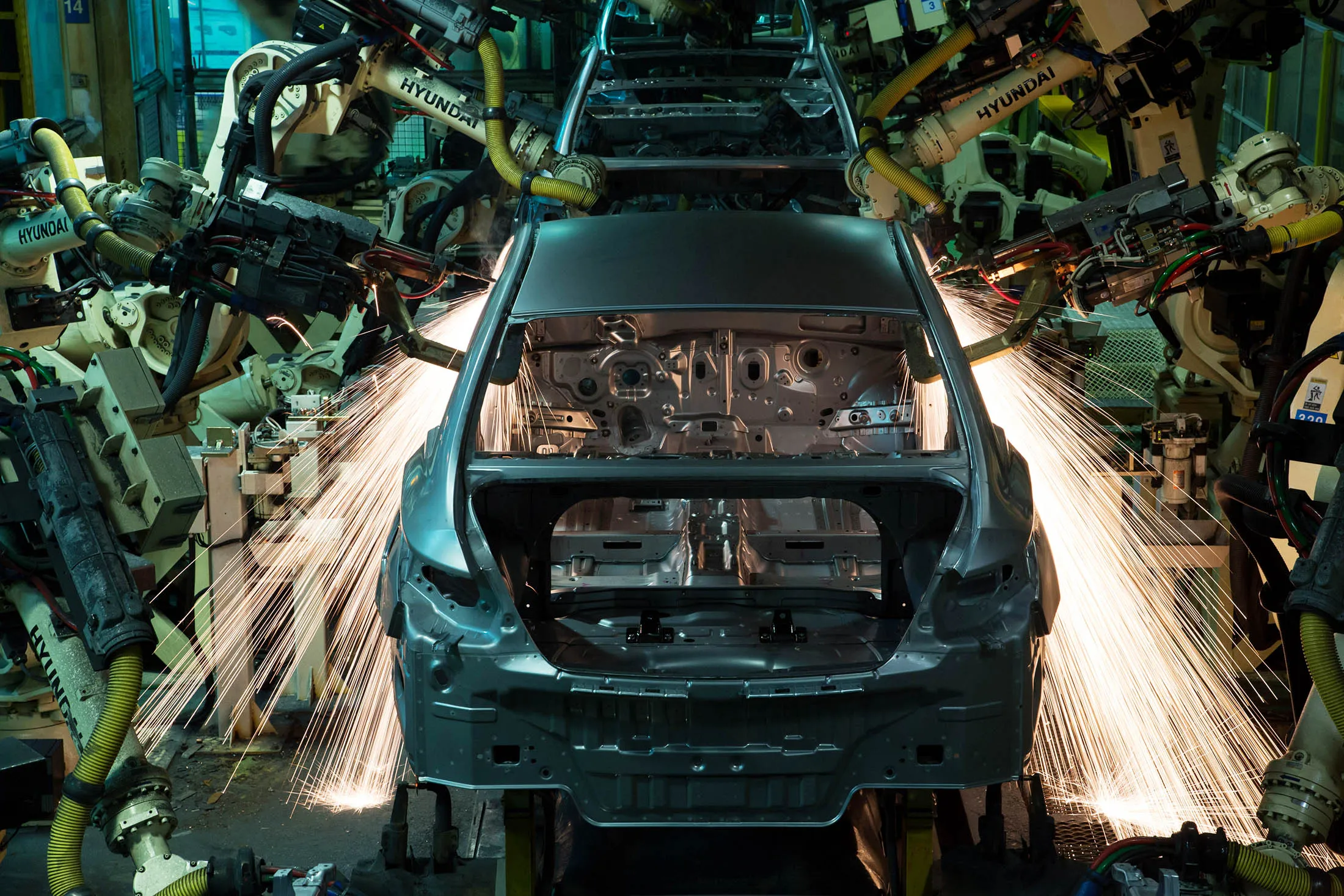 Robots weld frames of vehicle on the production line at the Hyundai Motor Co. factory in Asan, South Korea, on Monday, Jan. 21, 2014.
