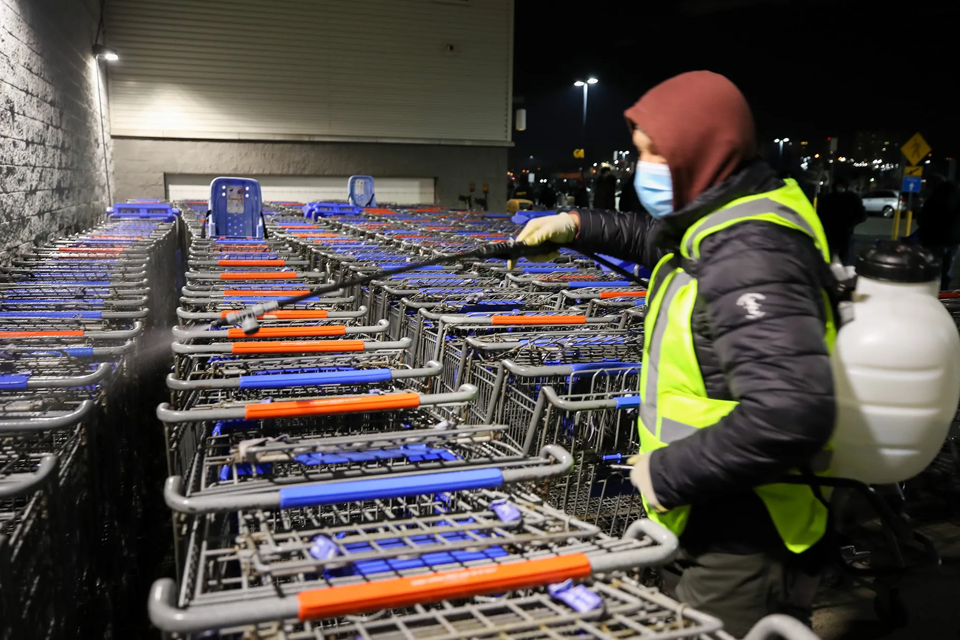 A man sanitizes shopping carts at Walmart in New Jersey, on Nov. 27.