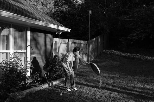Kosareva throws water from a bucket onto the grass of her backyard. 