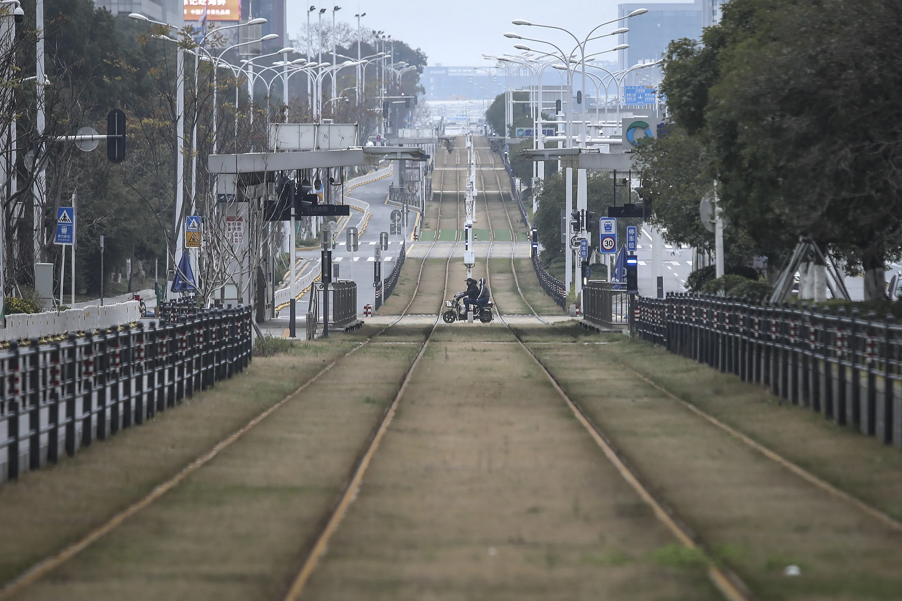 A resident rides a motorbike across an empty track in Wuahn on Feb. 7.