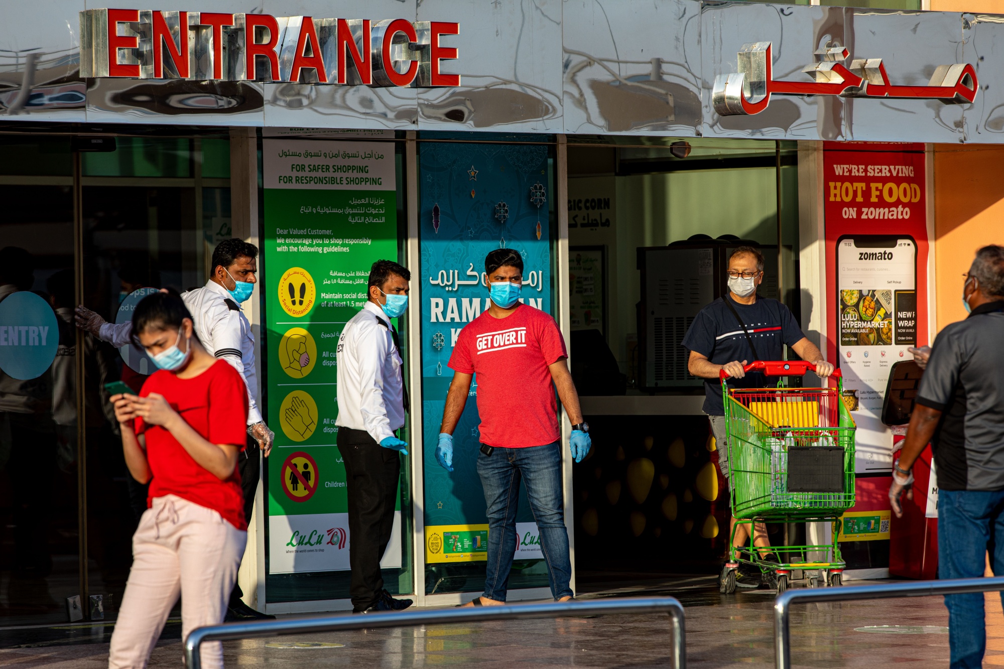 Security guards guide shoppers at the entrance of a market in Dubai, on April 23.