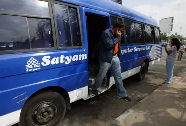 An Indian employee of Satyam Computer Services Limited descends from a bus as he arrives for work in Hyderabad. 