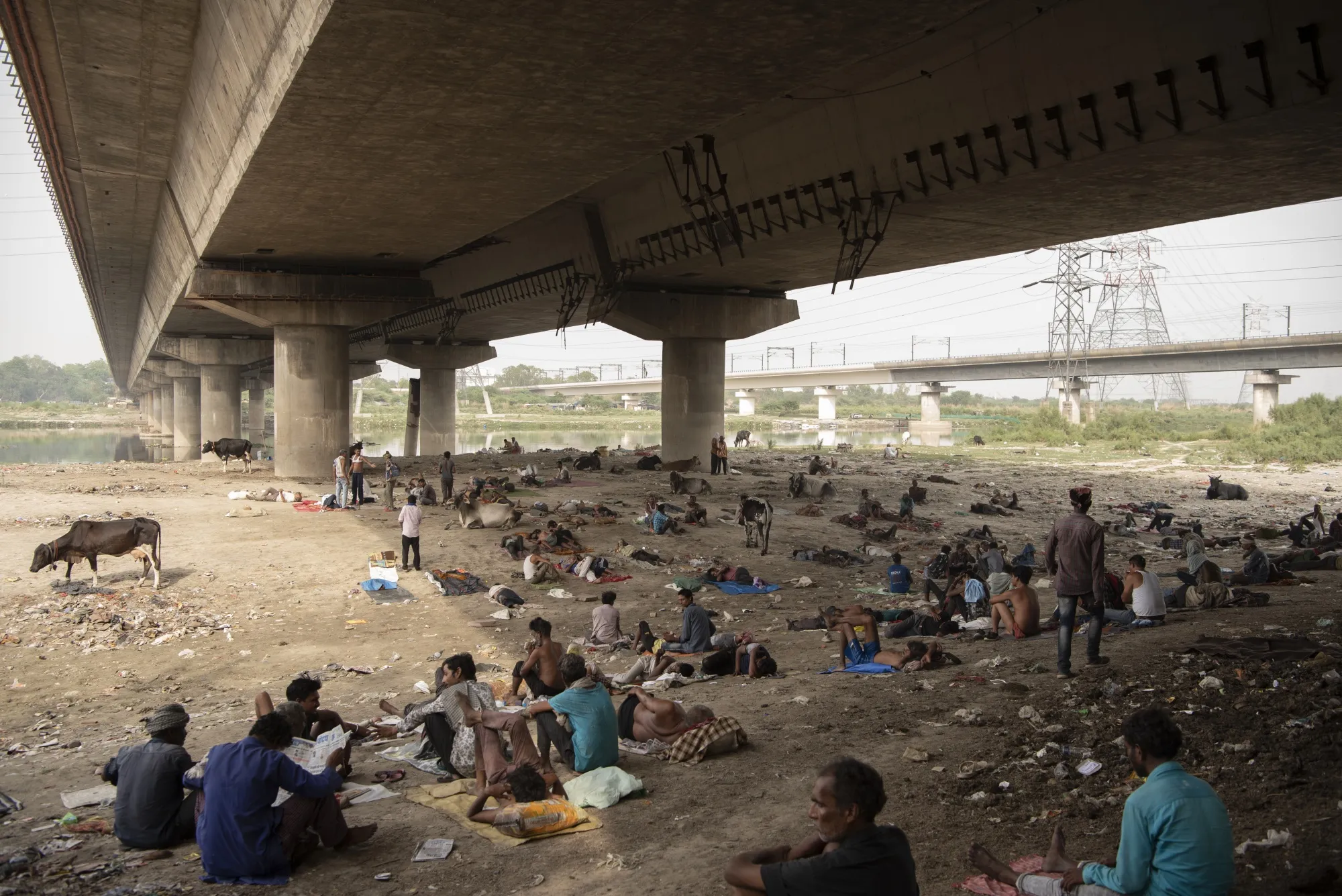 People rest under a bridge in New Delhi&nbsp;in May 2022.