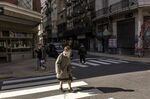A pedestrian wearing a protective mask and face shield crosses the street in Buenos Aires.