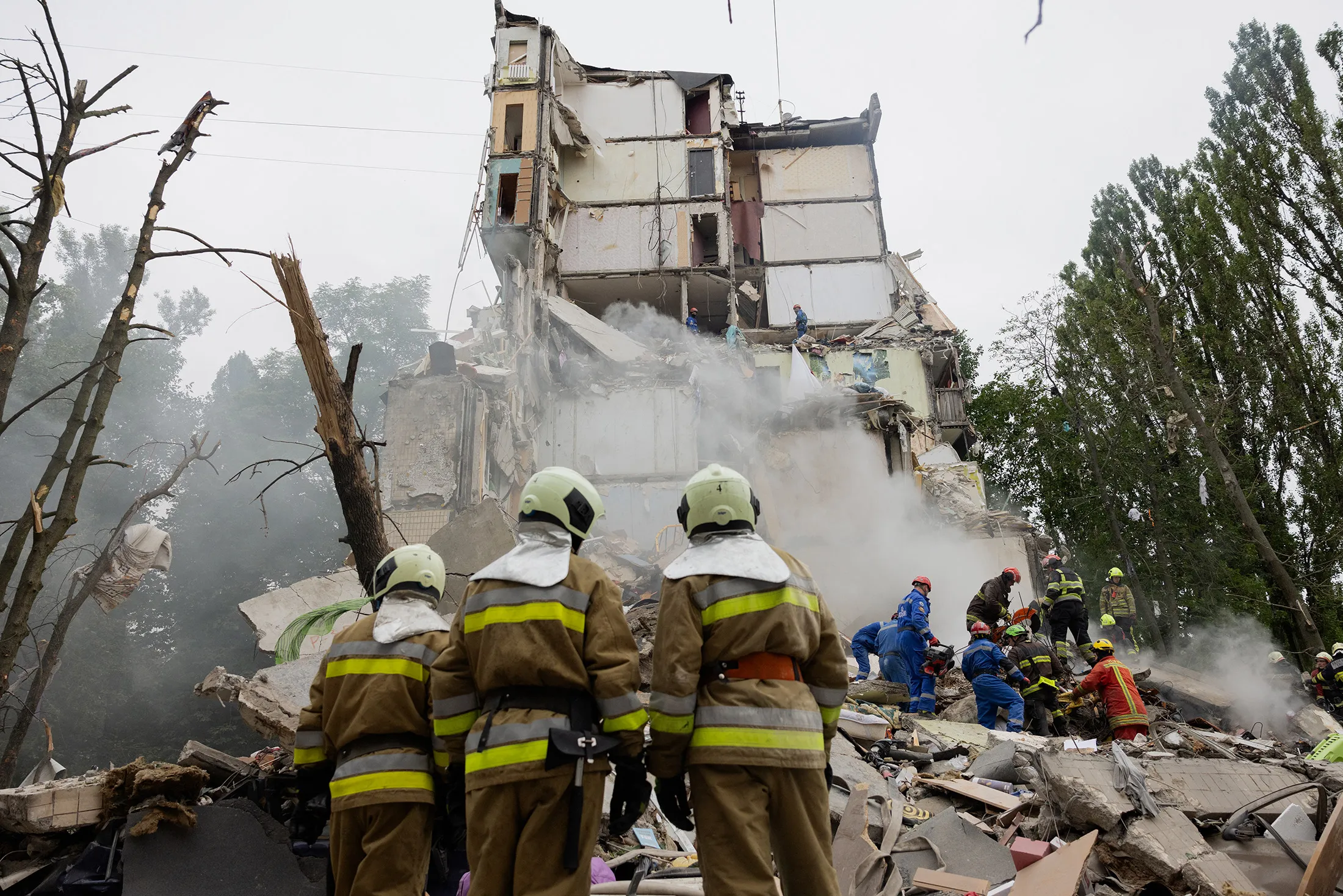Rescuers clear debris as they work at the site of a destroyed residential building following a Russian air attack in Kyiv on July 31.