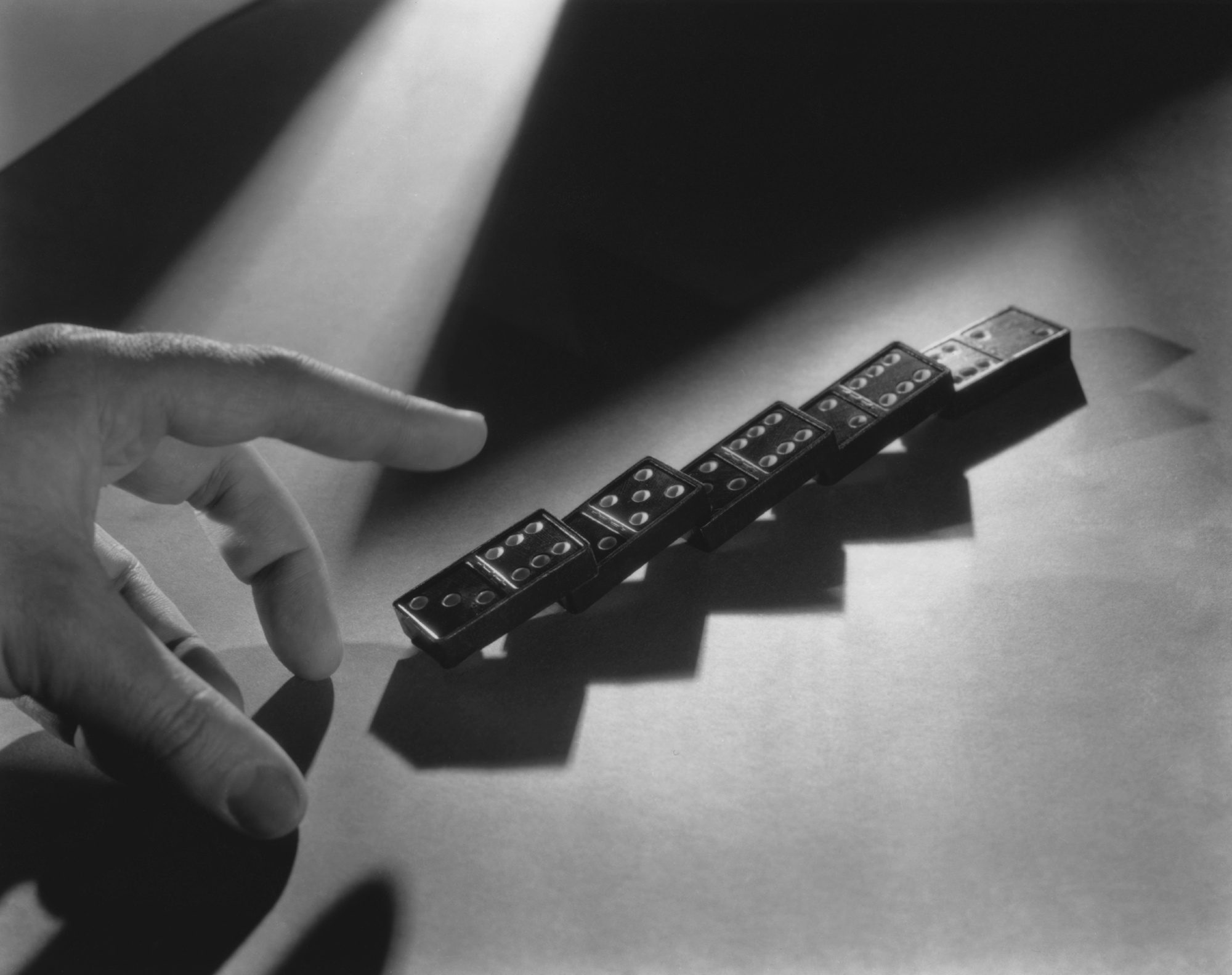 Close up of a hand and a line of dominoes. (Photo by Archive Photos/Getty Images)