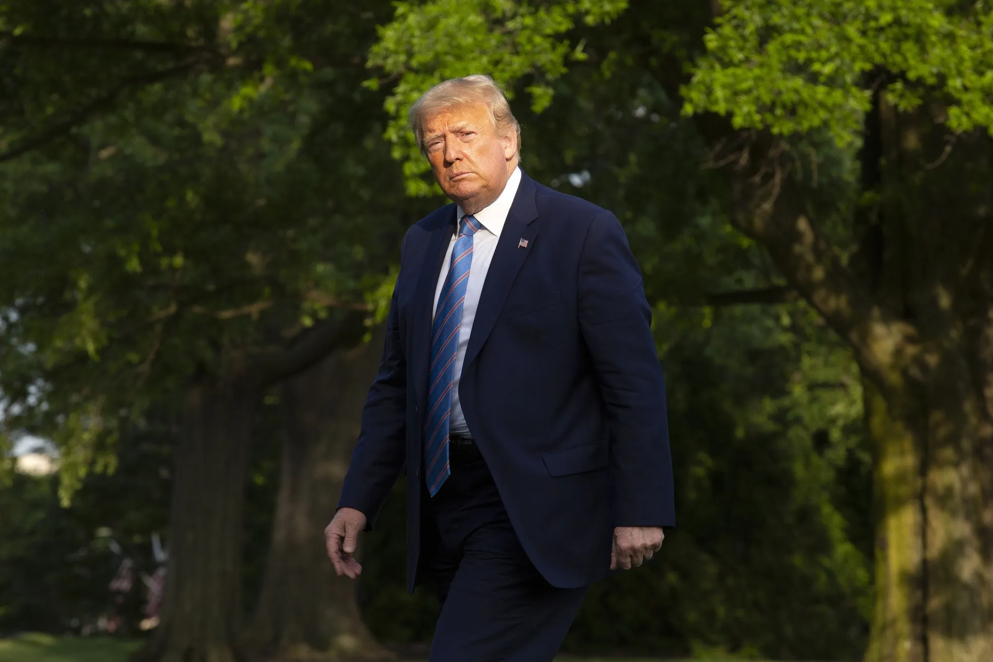 President Donald Trump walks on the South Lawn of the White House on Sunday.