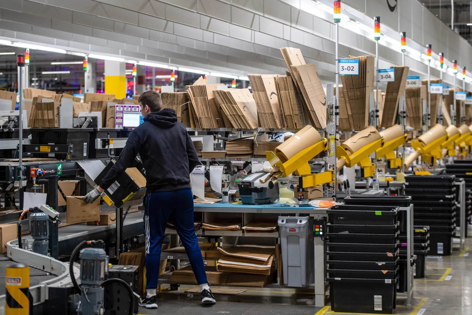 Employees work in a packing area at an Amazon fulfillment center.