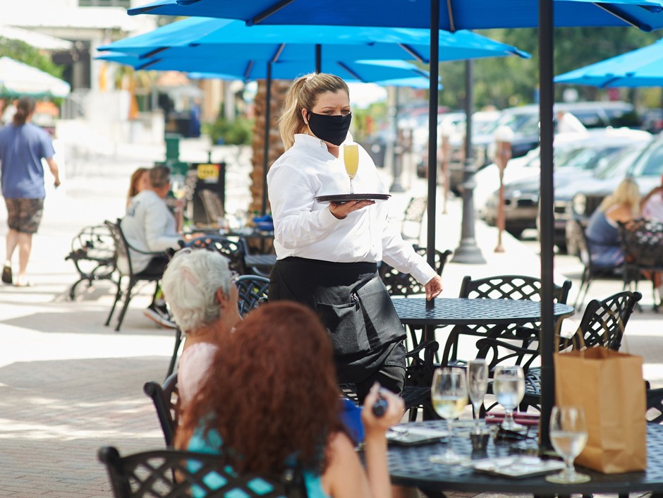 A masked server in the outside dining area of a restaurant in St. Petersburg, Florida, on May 4.