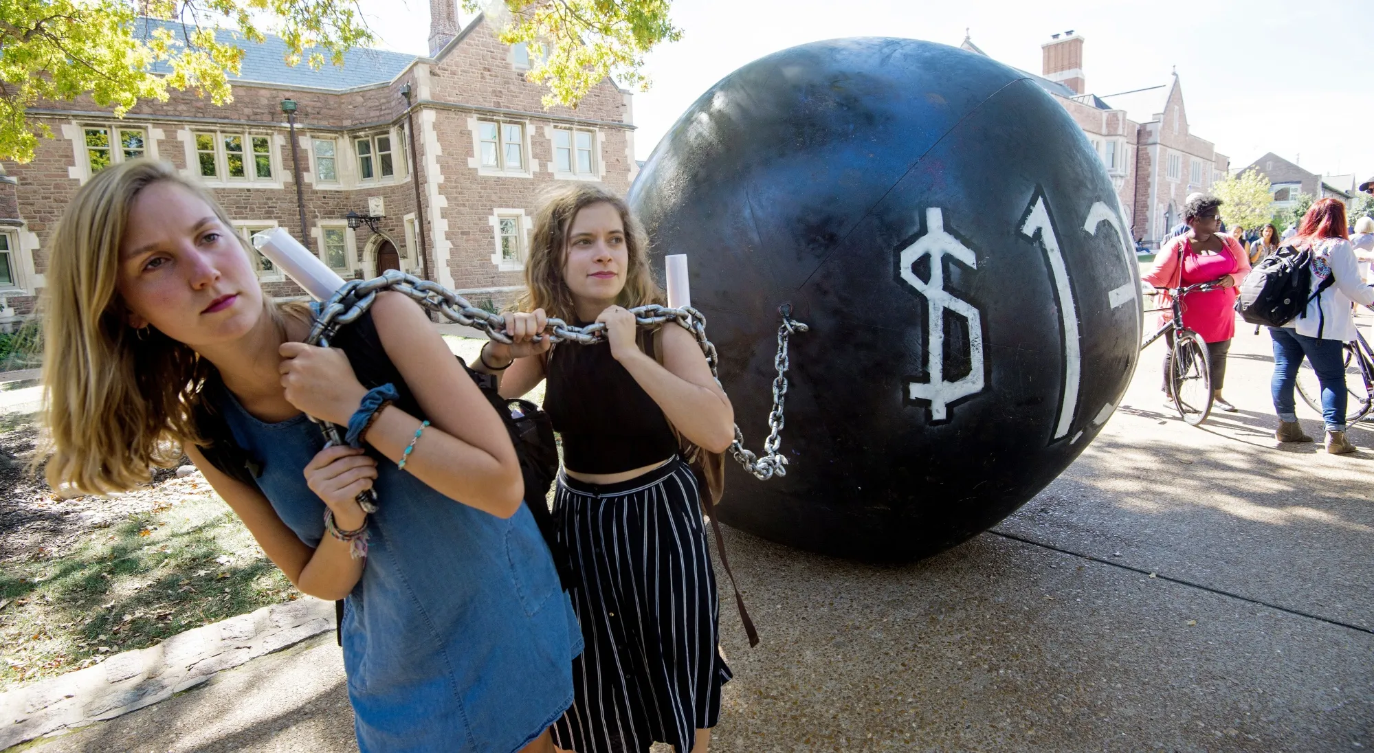 Students pull a mock "ball &amp; chain" representing the $1.4 trilling outstanding student debt at Washington University in St. Louis, Missouri.