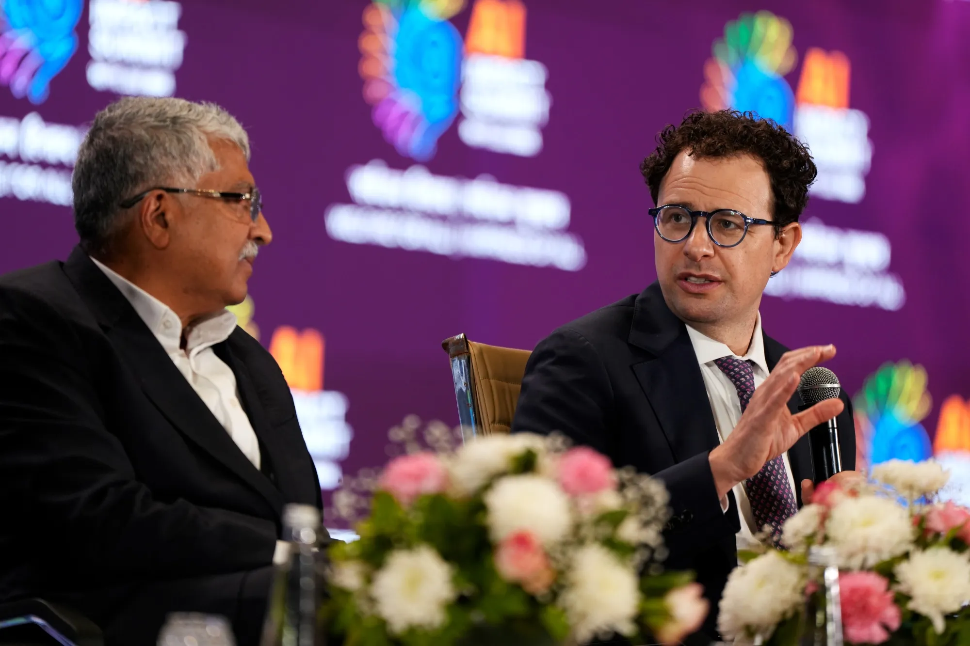 Anthropic CEO Dario Amodei, right, and Infosys co-founder Nandan Nilekani at the AI Impact Summit in New Delhi on Feb. 19.