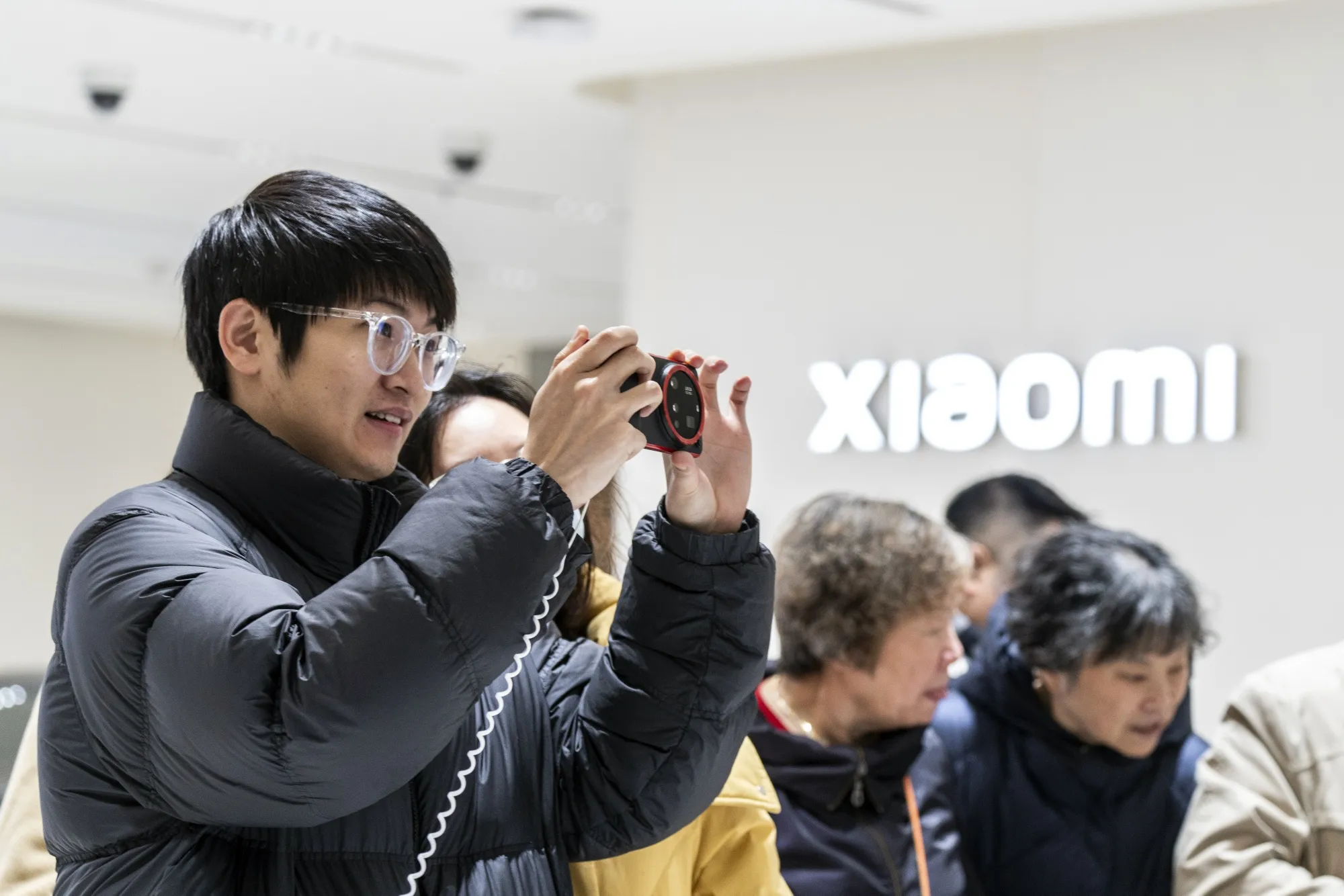 A customer looks at a Xiaomi Corp. smartphone in a store in Shanghai.