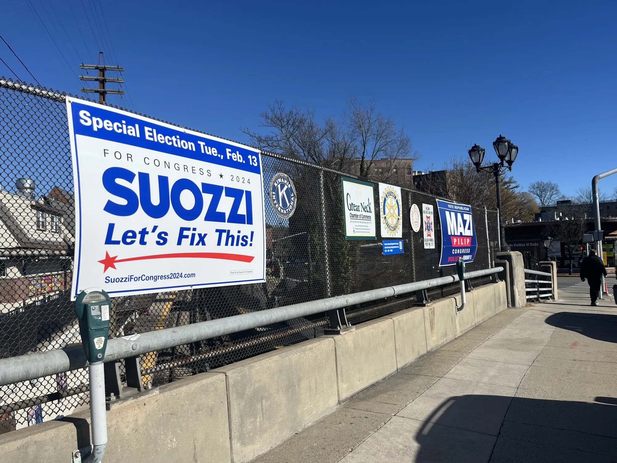 Signs for Tom Suozzi and Mazi Pilip hang on an overpass in Great Neck, New York.