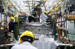 Workers assemble a vehicle at a prototype center in Guangzhou, China.
