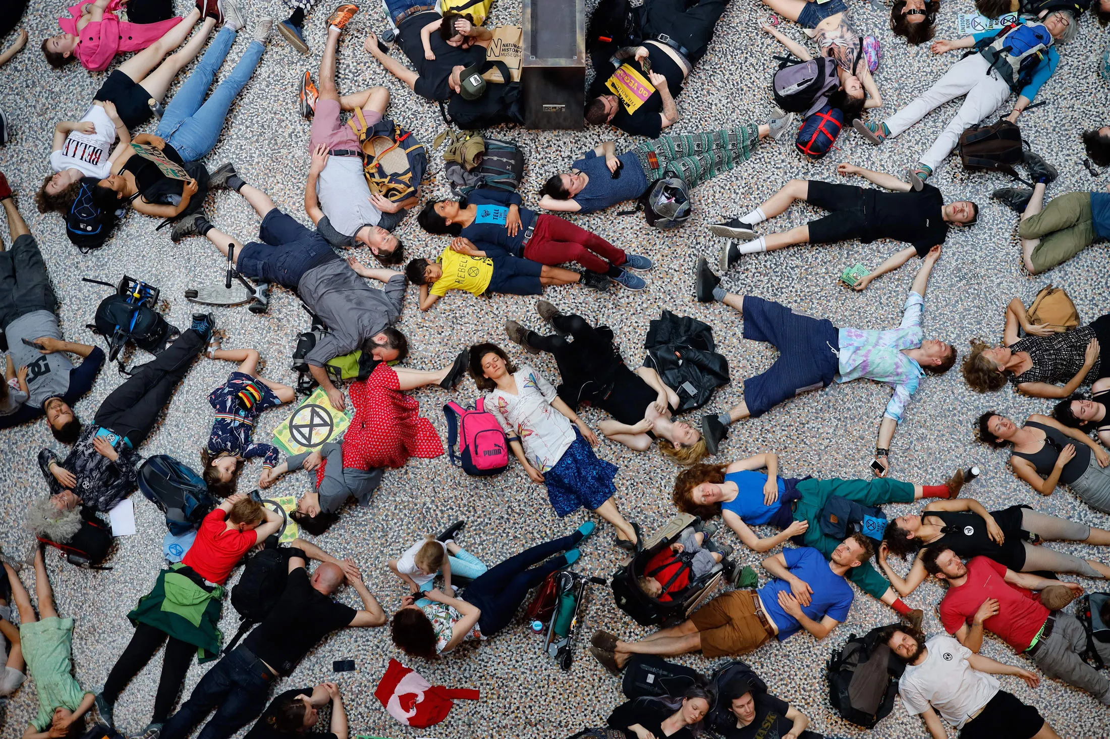 Extinction Rebellion climate change activists lie on the floor as they perform a mass "die in" in the main hall of the Natural History Museum in London on April 22, 2019.