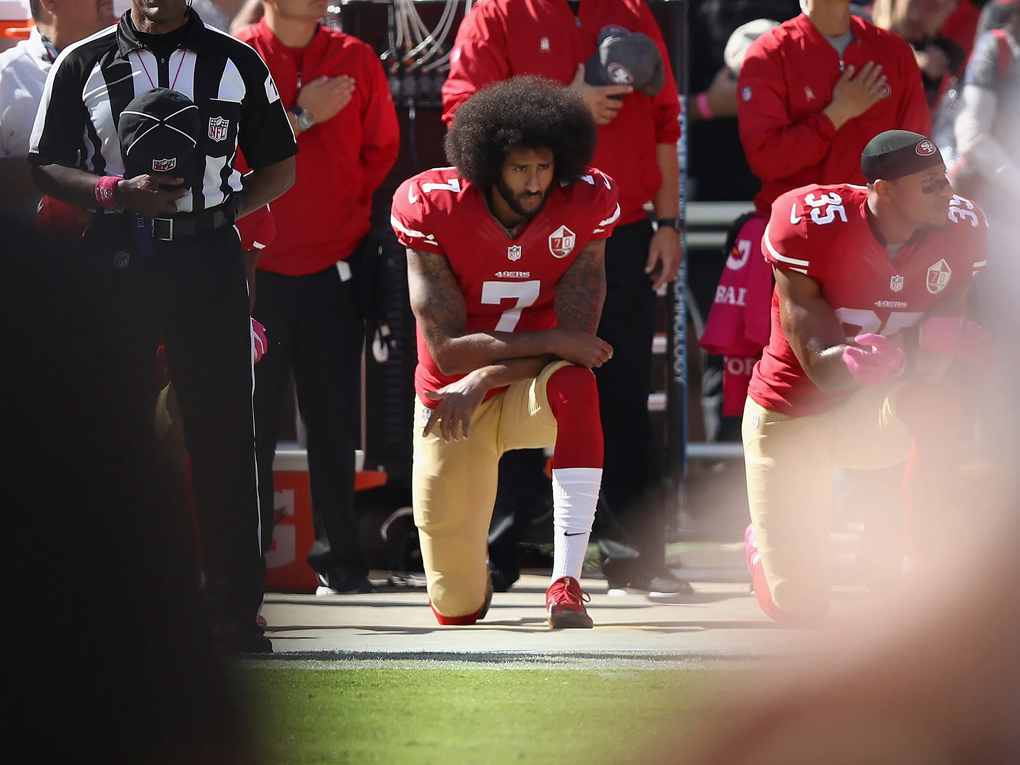Colin Kaepernick, center, kneels for the National Anthem before a game in 2016.