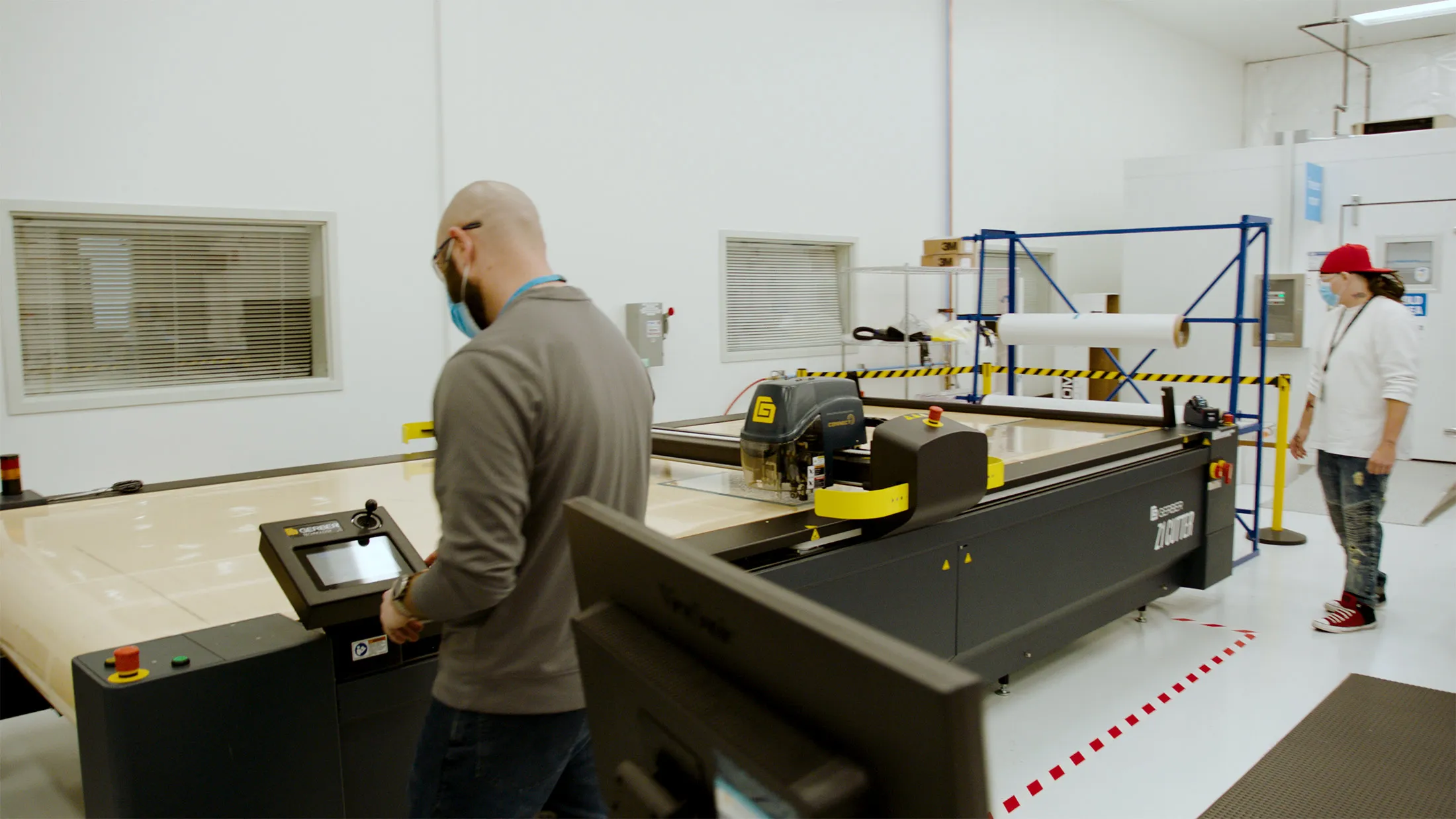 Employees use a machine&nbsp;that normally cuts carbon fiber for drone parts to slice screens for the face shields.
