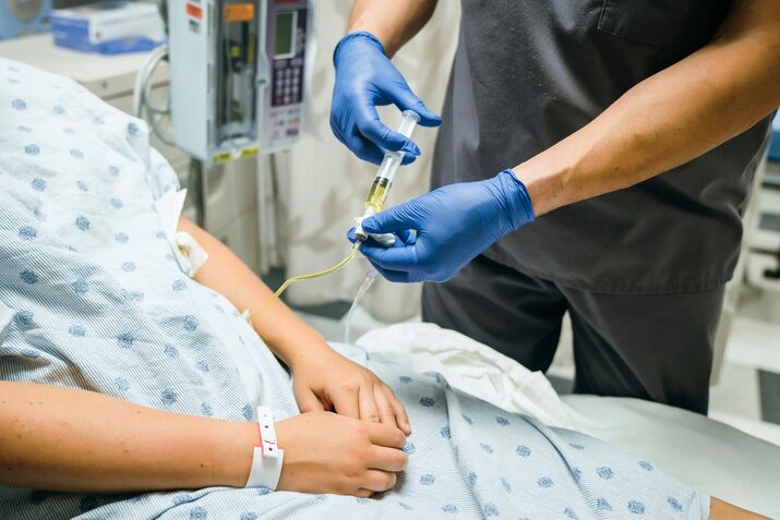 Nurse injecting medicine into tube of patient