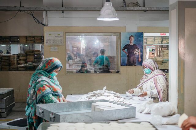 Workers examine soccer ball panels at Anwar Khawaja Industries.