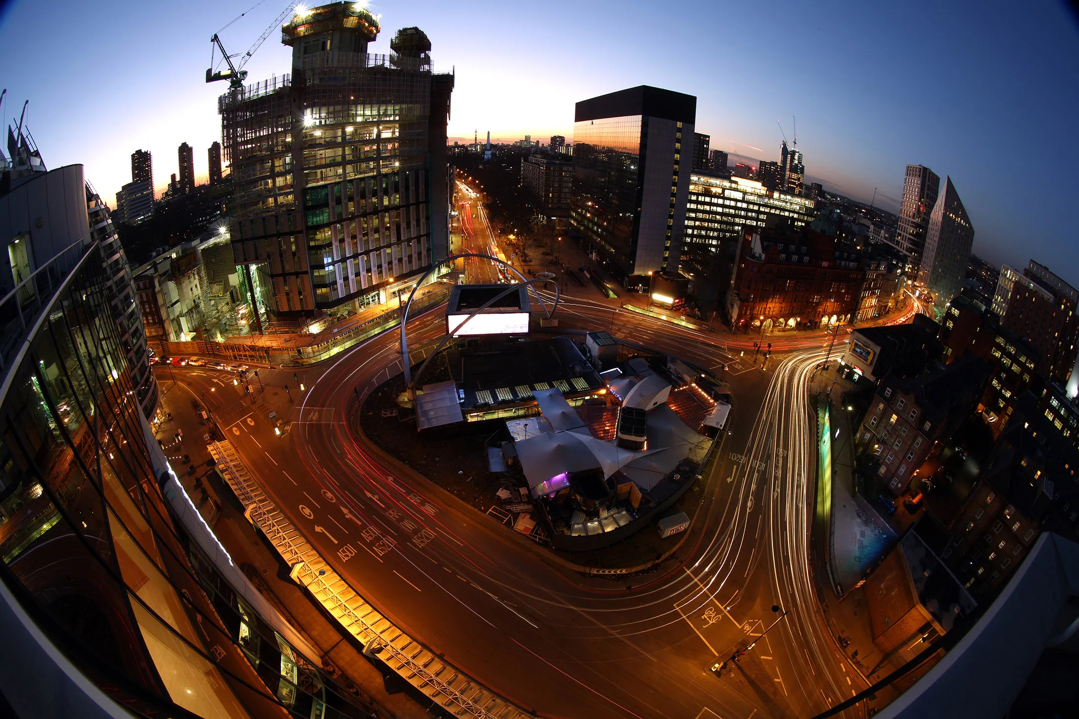 Light trails made by traffic passing around the Old Street roundabout, also referred to as 'Silicon Roundabout,' in the area known as 'Tech City' at dusk in London.
