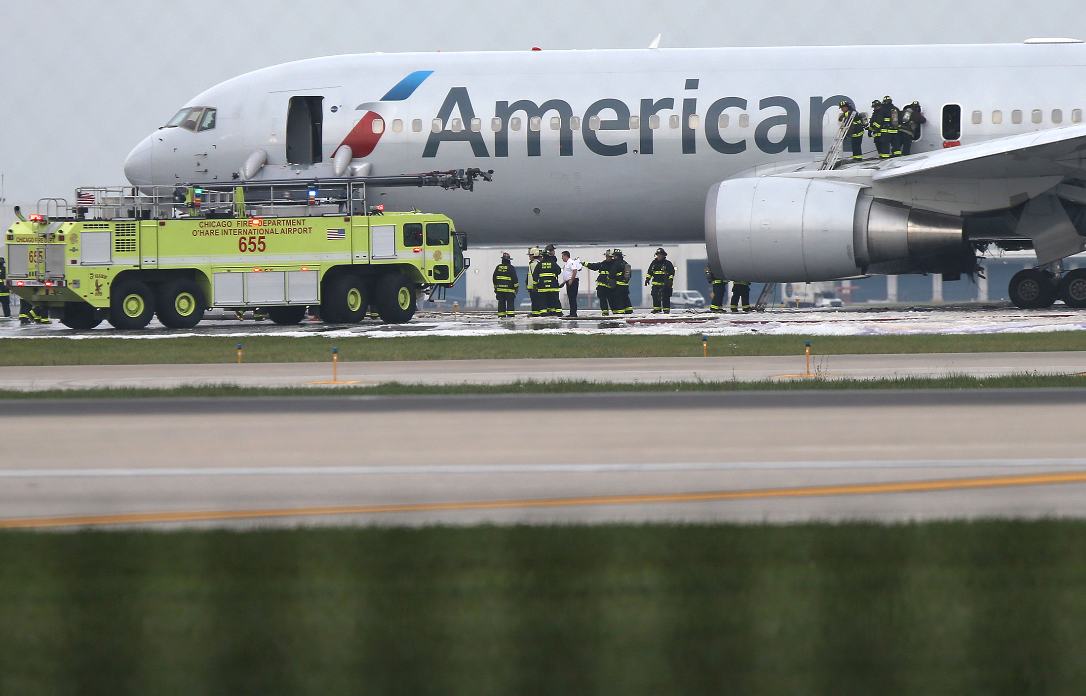 Firefighters extinguish flames from American Airlines Flight which caught fire on a runway at O'Hare International Airport in Chicago on Oct. 28, 2016.
