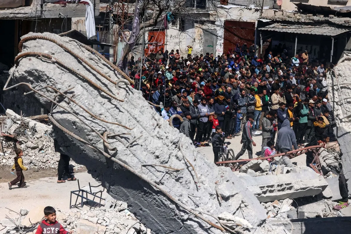 Palestinians perform the first Friday noon prayer of Ramadan in front of the ruins of Al-Farouq Mosque on March 15.