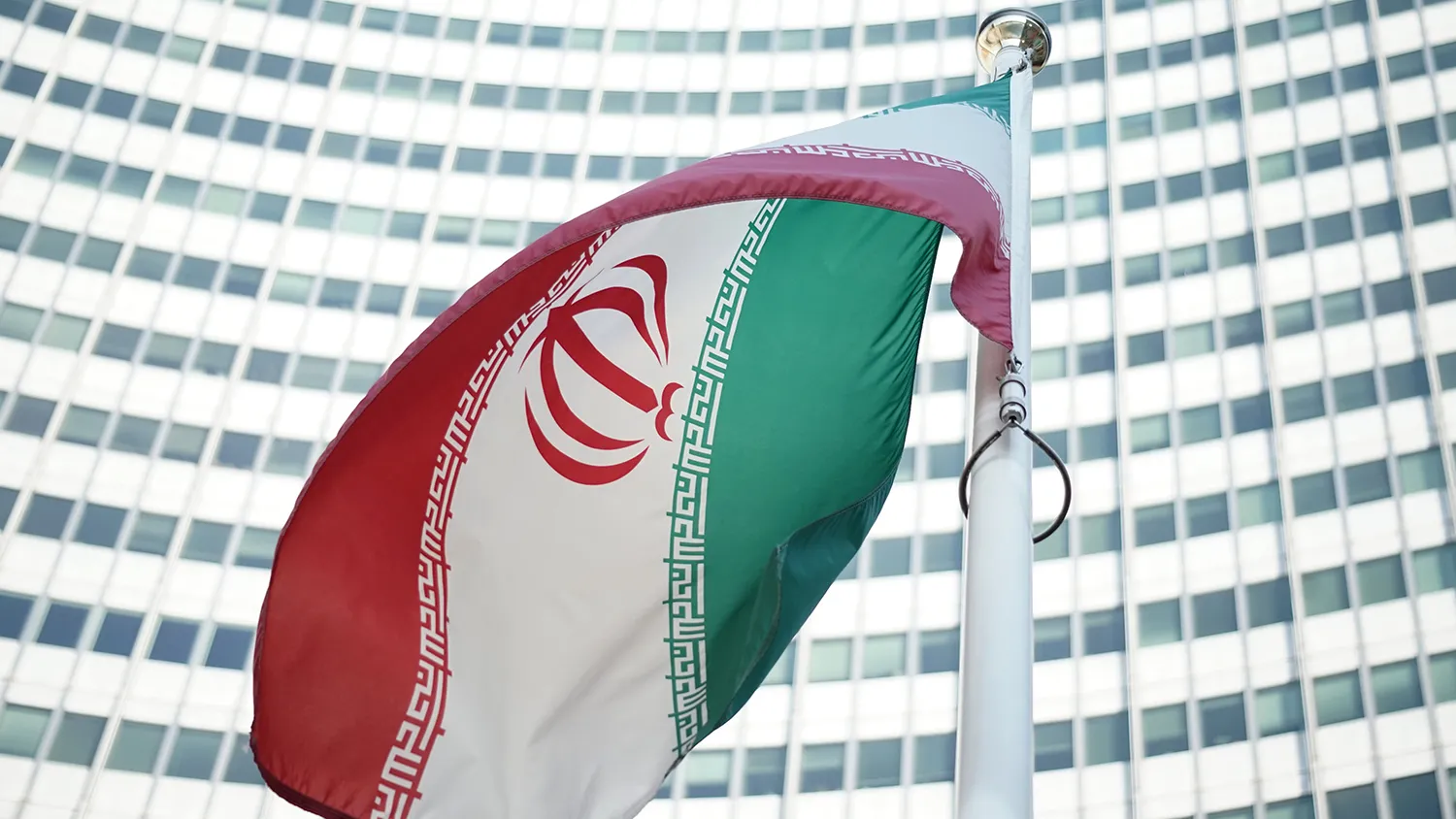 An Iranian flag waves in a wind outside the Vienna International Centre hosting the United Nations (UN) headquarters and the International Atomic Energy Agency (IAEA) as the socalled EU 5+1 talks with Iran take place in Vienna, on July 3, 2014.
