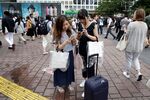 Young women play Pokemon Go on a street in Tokyo.
