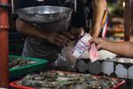 A shopper hands Philippines' Peso at a market in Mandaluyong.