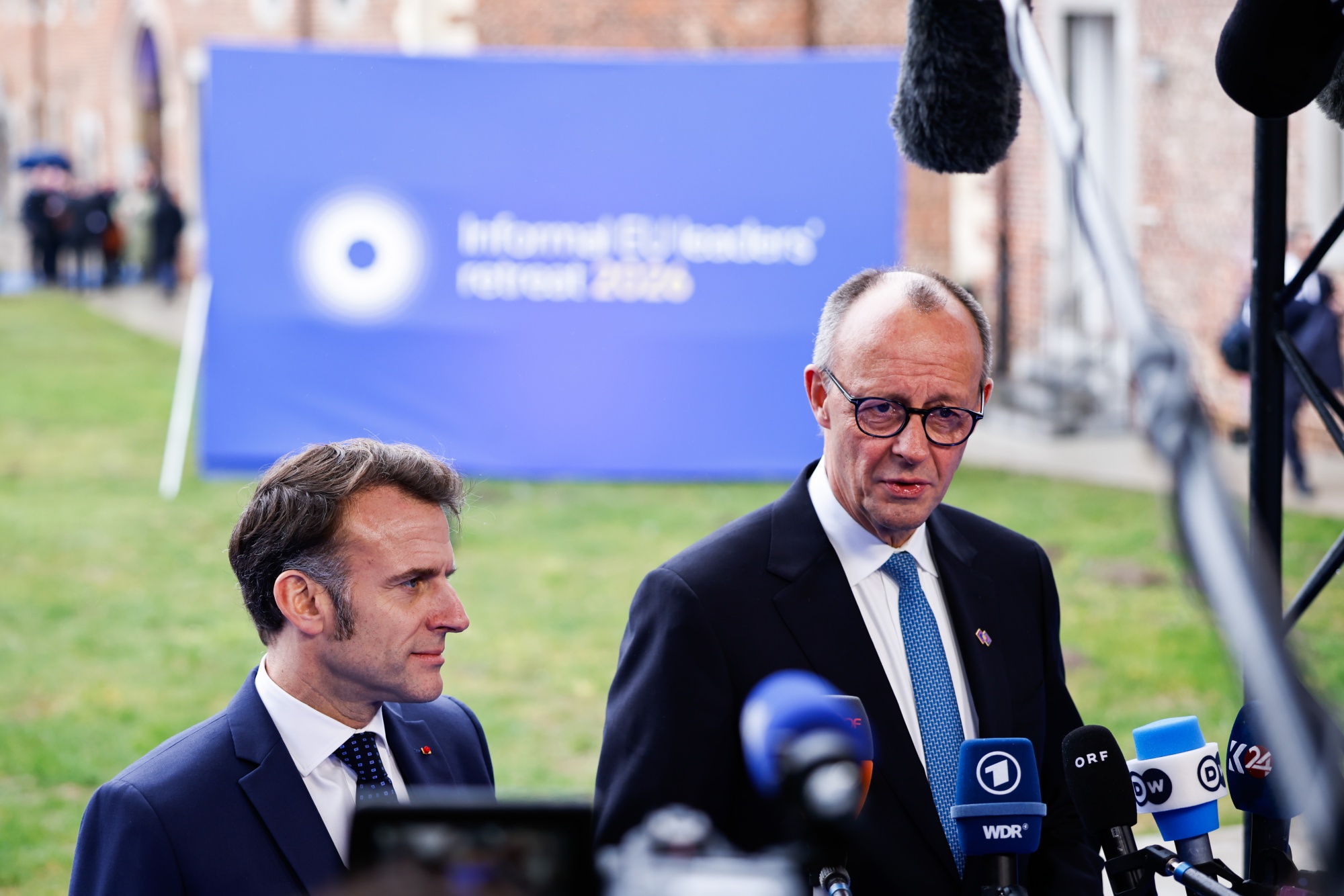 Emmanuel Macron, France's president, left, and Friedrich Merz, Germany's chancellor, arrive at an informal European Union (EU) leaders retreat at Alden Biesen Castle in Rijkhoven, Belgium, on Thursday, Feb. 12, 2026. EU leaders are to discuss ways to bolster the single market amid new geoeconomic challenges. Photographer: Simon Wohlfahrt/Bloomberg