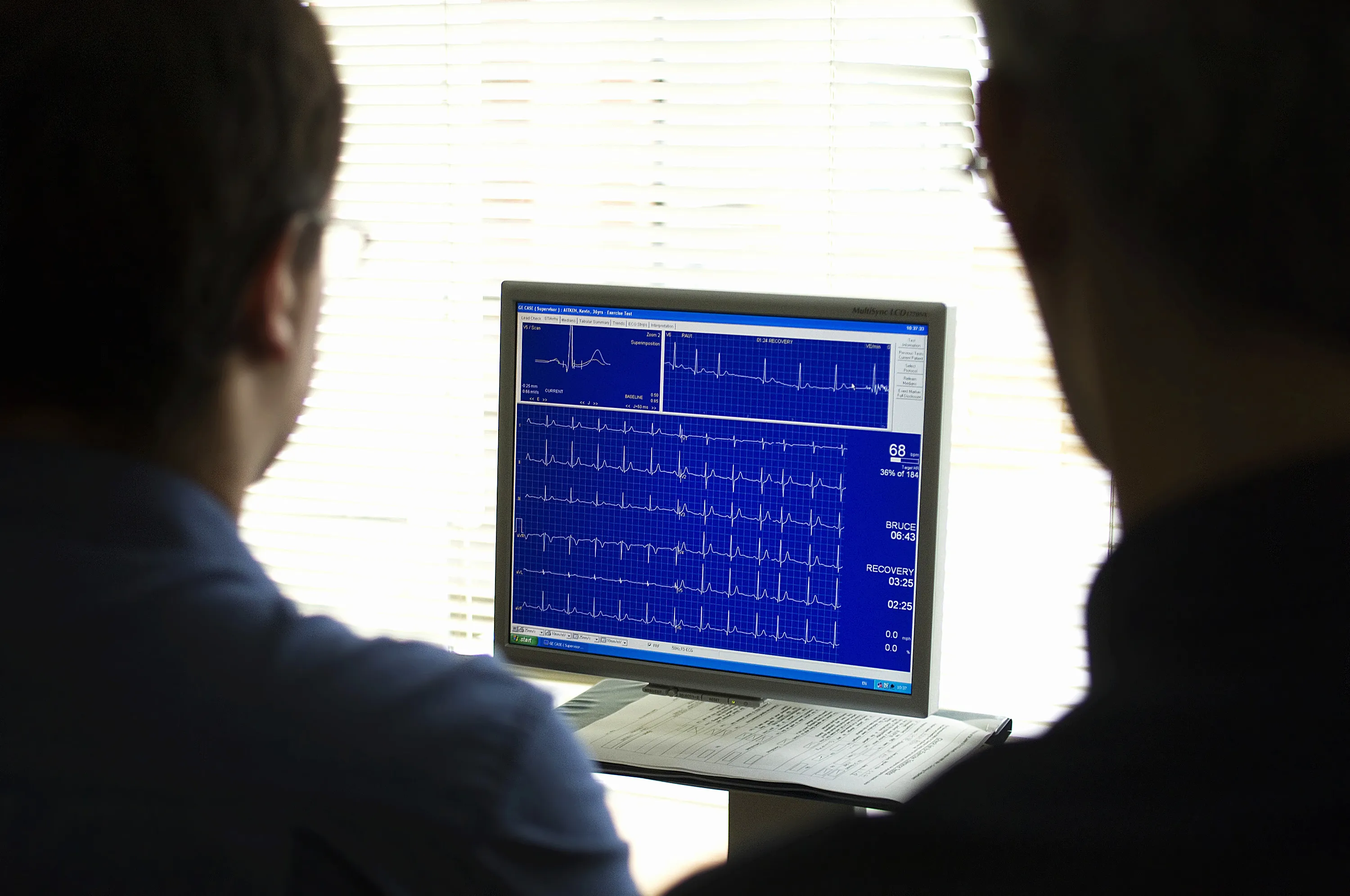 Doctors monitor an electrocardiogram recording of a patient's cardiac cycle produced by an electrocardiograph.